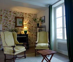 a living room with two chairs and a table at Un bijou au cœur de Belleme in Bellême