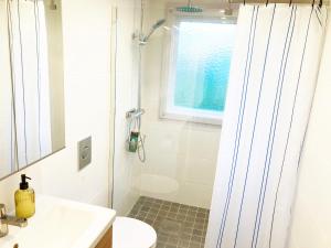 y baño blanco con lavabo y ducha. en Villa with 4 bed rooms with internet in Vimmerby en Gullringen