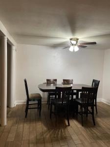 a dining room with a table and chairs and a ceiling fan at Necessary Retreat in Orlando