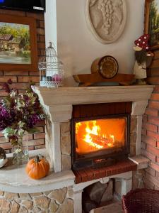 una chimenea con una calabaza sentada frente a ella en Karczma Regionalna Młyn -pokoje gościne, en Zwierzyniec