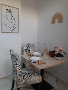 a dining room table with zebra chairs and a table with plates at Santa Marta in Martos