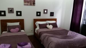 リスボンにあるTurkish Style Hostelのベッドルーム(紫のシーツを使用したベッド2台付)