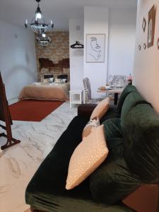 - un salon avec un canapé vert et un lit dans l'établissement San Amador, à Martos