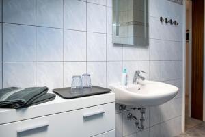 a white bathroom with a sink and a mirror at Ferienwohnung Bad Kissingen in Bad Kissingen +28 photos
