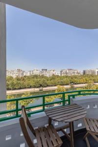 a balcony with a table and chairs and a river at HOLT - Leagues and Words Under The Sea in Bucharest