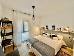 Un dormitorio con una gran cama blanca y una ventana en El rincón del Indiano, en Santander