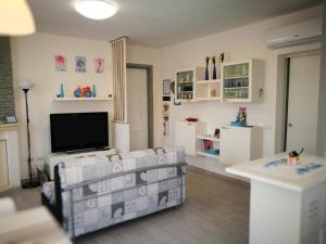 een woonkamer met een bank en een flatscreen-tv bij Casa Mariuccia in Valledoria