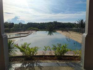 una piscina de agua con bancos en un parque en Santubong Suites Sejinjang en Kuching