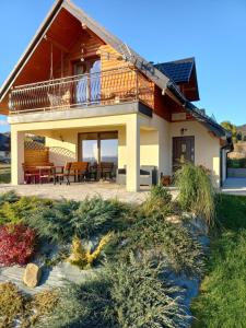 a house with a balcony and a patio at Domek na Hubce in Maniowy