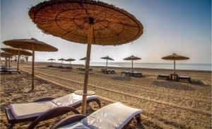 una playa con sillas y sombrillas en la arena en HOUSE CLOSE TO THE BEACH Mar Menor, en Los Narejos