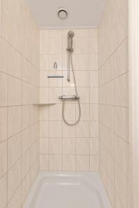 a bath tub with a shower in a bathroom at Vakantiehuis 6p Meddo in Winterswijk-Meddo