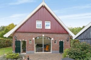 a red barn with a large window at Vakantiehuis 6p Meddo in Winterswijk-Meddo