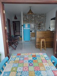 a kitchen with a table and a blue refrigerator at Chalé Sunset Taipu de Fora in Marau