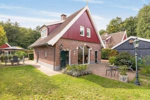 a red brick house with a patio and yard at Vakantiehuis 6p Meddo in Winterswijk-Meddo
