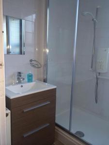 3 bedroom flat in Maida Vale في لندن: حمام مع دش ومغسلة