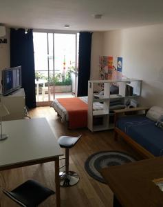 Habitación con 1 dormitorio con 1 cama y TV. en Dormy en Belgrano en Buenos Aires