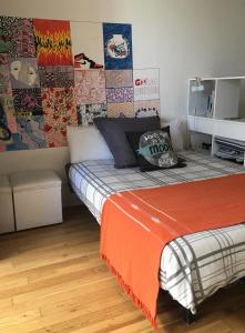 1 dormitorio con 1 cama con colchas de colores en la pared en Dormy en Belgrano en Buenos Aires