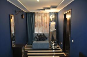 a mannequin standing in a room with a blue wall at Dwell Apartments in Kremenchuk