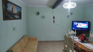 a living room with a couch and a tv at Don Oscar Alojamientos Dpto Lenna in San Justo