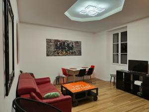 a living room with a red couch and a table at Les Lofts De Provins: Apt 4 in Provins