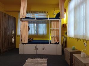 a room with two bunk beds and a yellow wall at Tag Along 2 0 Hostel Gangtok in Gangtok