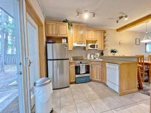 a kitchen with wooden cabinets and a stainless steel refrigerator at MountainView -PrivateChalet Sleep7- 5min to DT Vacation Home in Canmore