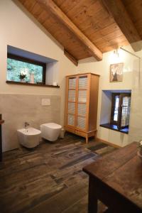 bagno con due servizi igienici, lavandino e finestra di Lupus in fabula a Peveragno