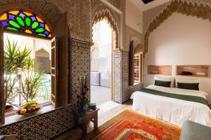 a bedroom with a bed and a stained glass window at Riad Zyo in Rabat