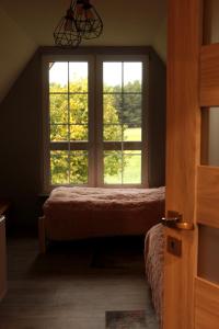 1 Schlafzimmer mit 2 Betten und 2 Fenstern in der Unterkunft Chata Nova in Milejczyce