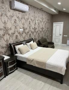 sypialnia z dużym łóżkiem i krzesłem w obiekcie Eurolux Boutique-Hotel w Taszkiencie