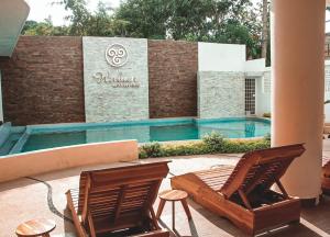 two chairs sitting next to a swimming pool at Hubun Hotel Boutique in Los Ayala