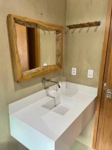a bathroom with a sink and a mirror at CHALEVILLE Coqueiro 46 in Luis Correia