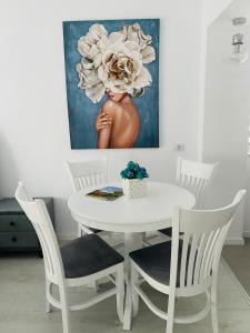 uma mesa branca e cadeiras num quarto com uma pintura em Luxury Prince em Câmpulung Moldovenesc