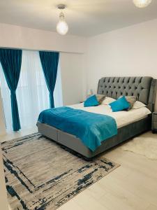 ein Schlafzimmer mit einem großen Bett mit blauen Kissen in der Unterkunft Luxury Prince in Câmpulung Moldovenesc