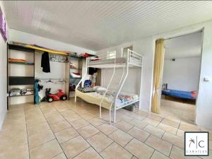 ein Schlafzimmer mit Etagenbetten und Fliesenboden in der Unterkunft Maison de Vacances BELIOSEA Martinique 14 Rue d'Anjou in Saint-Pierre