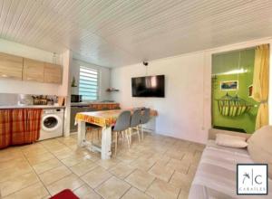 a living room with a table and a kitchen at Maison de Vacances BELIOSEA Martinique 14 Rue d'Anjou in Saint-Pierre