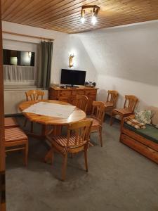 a room with a table and chairs and a television at Ferienhaus am Rennsteig-Pension zur Wetterwarte in Brotterode-Trusetal