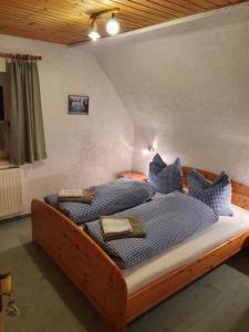a bedroom with a bed with blue and white pillows at Ferienhaus am Rennsteig-Pension zur Wetterwarte in Brotterode-Trusetal