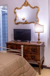 フィレンツェにあるCasa Savonarola Charmeのベッドルーム(鏡付きドレッサーのテレビ付)