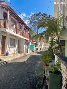 an empty street with a palm tree and buildings at Maison de Vacances BELIOSEA Martinique 14 Rue d'Anjou in Saint-Pierre