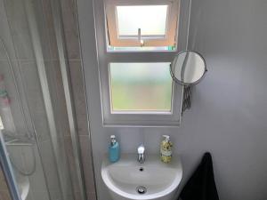 a bathroom with a sink and a window and a mirror at Old Ferry View in Bristol