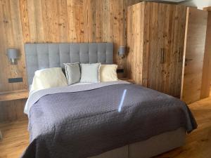 sypialnia z dużym łóżkiem i drewnianymi ścianami w obiekcie Lodge14 w mieście Kirchberg in Tirol