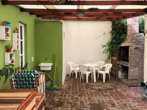 un patio con mesa, sillas y chimenea en Duplex Vivero Miramar Argentina en Miramar