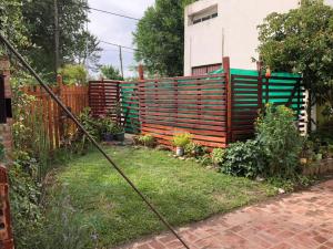 a fence in a backyard with a garden at Duplex Vivero Miramar Argentina in Miramar