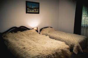 two beds in a bedroom with white fur at Casa Mario in Dragoslavele