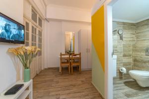a bathroom with a toilet and a tv on a wall at Paamonim Studios in Jerusalem