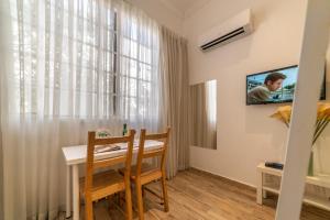 a dining room with a table and a tv on the wall at Paamonim Studios in Jerusalem +26 photos