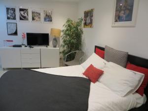 Schlafzimmer mit einem Bett mit roten und weißen Kissen in der Unterkunft FLH Casa Carol Mouraria in Lissabon