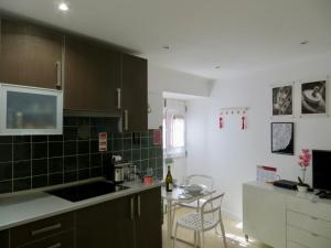 uma cozinha com azulejos verdes nas paredes e uma mesa em FLH Casa Carol Mouraria em Lisboa