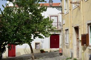 リスボンにあるFLH Casa Carol Mourariaの赤い扉の前の木